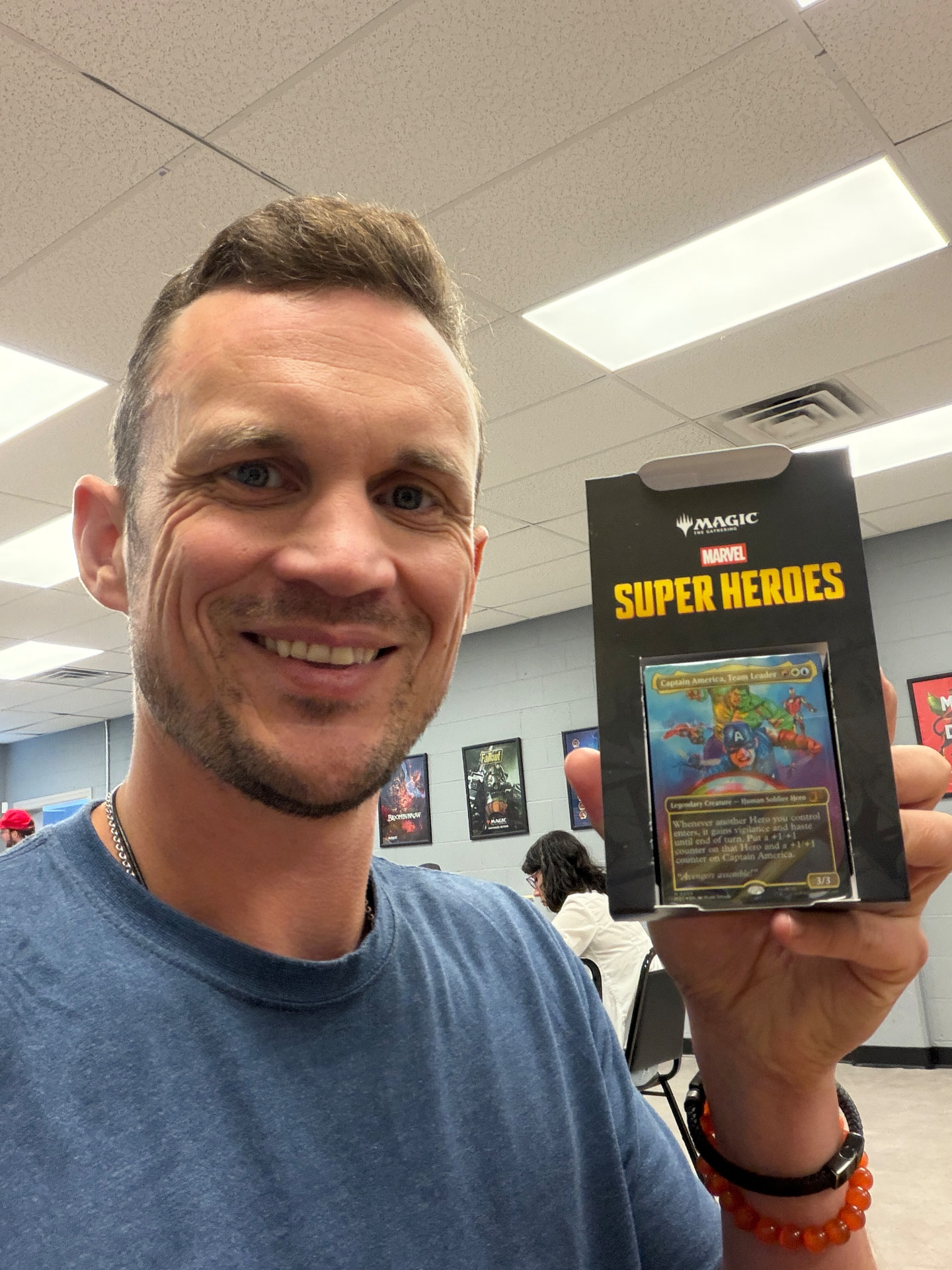 Eric holding a Marvel Super Heroes Magic: The Gathering booster showing Captain America